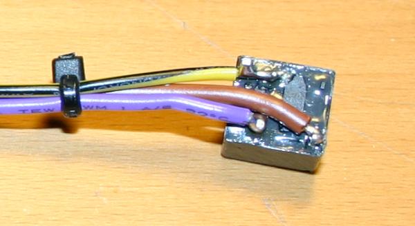 Je ein Kontakt von Spule und Schließer werden auf Masse gelegt (gelb/schwarz), das violette Kabel wird über den Schließer auf Masse gezogen und das braune Kabel liefert die Schaltspannung für das Relais.